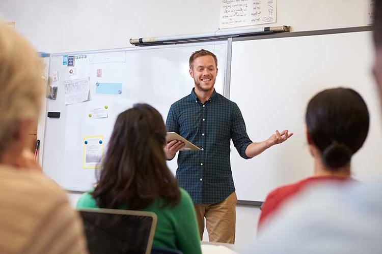 Faculty standing in front of class teaching